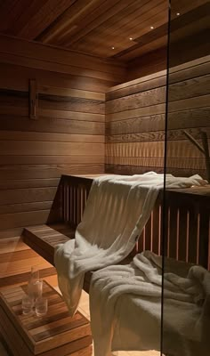 the inside of a wooden sauna with white towels on it