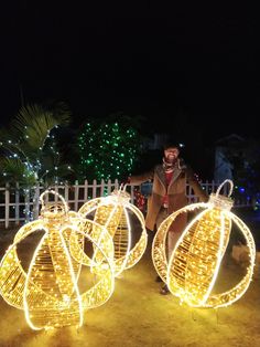 a man standing next to three lighted balls