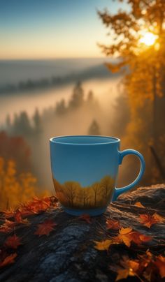 a coffee cup sitting on top of a tree stump in front of a forest filled with leaves