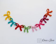 an image of colorful crocheted ribbon necklace on white background with text overlay