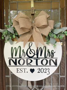 a door hanger that says mr and mrs horton est, with a bow on it