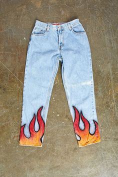 a pair of jeans with flames painted on them