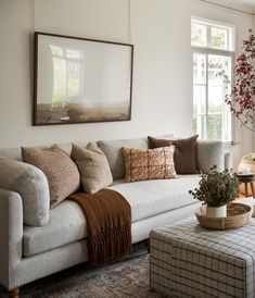 a living room filled with lots of furniture and pillows on top of a white couch