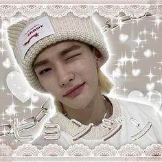 a young man wearing a white hat with hearts on it's side and the word love written in arabic