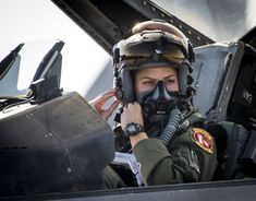 a female fighter pilot in the cockpit of an aircraft