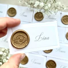 a person holding up a piece of paper with some gold coins in front of them