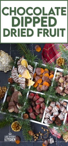 chocolate dipped fruit is displayed on a table with pine cones and other holiday decorations around it