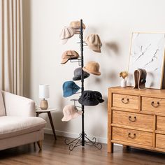 a hat rack in the corner of a room next to a white couch and wooden dresser