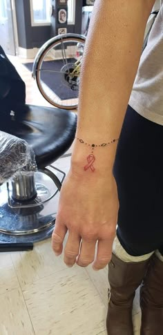 a person with a red ribbon on their wrist and a bike in the back ground