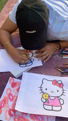 a person sitting at a table with some art work on the ground next to them