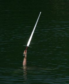 a pole sticking out of the water in the middle of the night with lights on it