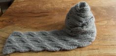 a gray knitted sock sitting on top of a wooden table