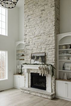 a living room filled with furniture and a fire place in front of a brick wall