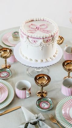 a table topped with a white and pink cake