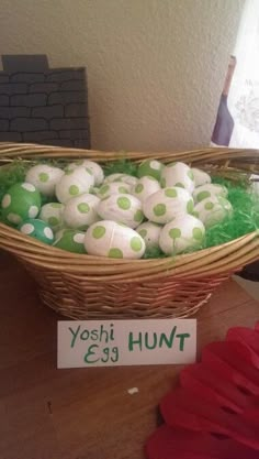 a basket filled with balls sitting on top of a table next to a sign that says yoshi hunt