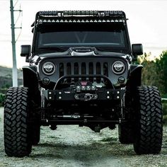 the front end of a black jeep with lights on