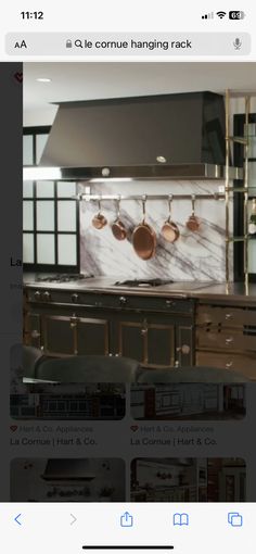 an image of a kitchen with pots and pans hanging on the wall above it