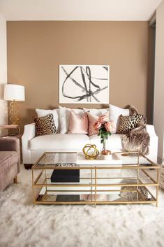 a living room with white couches and leopard print pillows on the back of them