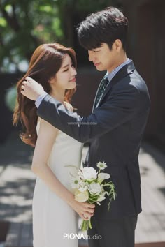 the young couple is posing for their wedding photo