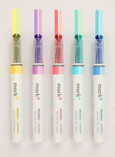 four different colored pens lined up next to each other on a white surface with the same color