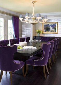 a dining room with purple chairs and a chandelier