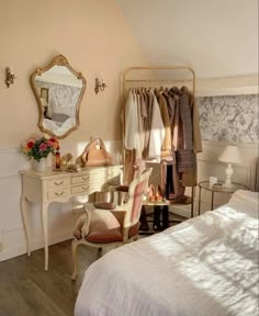 a bedroom with a bed, dressing table and mirror on the wall next to it