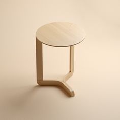 a small wooden table sitting on top of a white floor next to a beige wall