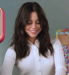 a woman in white shirt standing next to a bed