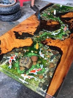 a table made out of wood and glass with koi fish in the water on it