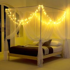 a bed that has some lights on top of it and is in the middle of a room