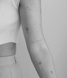 a woman's arm with small stars and planets on the back of her arm