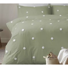 a green bed with white polka dots on it