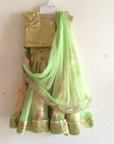 An absolutely fabulous floral lehenga from Bubblinga. The lehenga has a trendy sequin blouse with matching green piping at the neck and sleeves. The blouse is completely lined in cotton and piping at the hem , sleeve and neck prevents the sequin from coming in contact with skin. The skirt is a gorgeous twirly affair with a floral fabric with a tulle overlay in peach. The tulle is cut into kalis to get maximum flare. There are gold borders at the hem and waistline. The skirt has ties at the waist for the perfect fit and the skirt is also lined in cotton for additional body and comfort. Dress is custom made. Once you order I'll send you a measurements sheet which you need to fill out with your child's measurements. Alternately, you could just choose an age group in which case I would use the Kids Designer Outfits, Lehenga Floral, Sequin Lehenga, Floral Lehenga, Bridal Outfit, Sequin Blouse, Kids Couture, Designer Outfits, Different Dresses