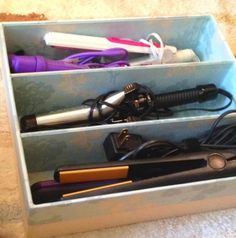 three different types of hairdryers in a blue box on the carpeted floor