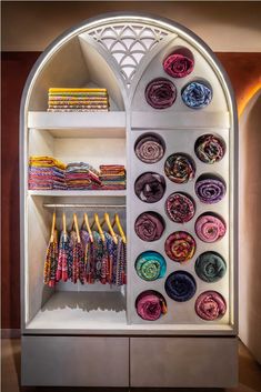 a display case with scarves and scarfs hanging on it's side wall