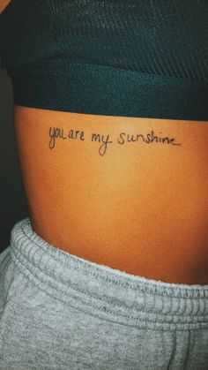 a woman's stomach with the words you are my sunshine written on her lower back