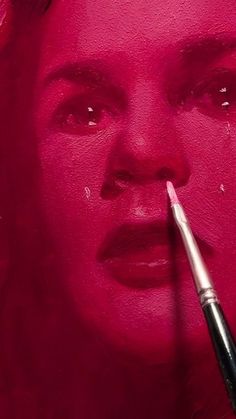 a woman's face is painted with pink paint