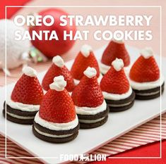 there are some cookies with strawberries on top and santa hats on the top one