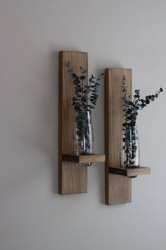 two vases with flowers are on the wall next to each other, one is holding water