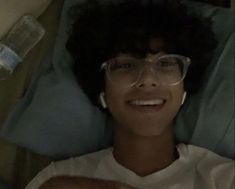 a person laying in bed with glasses on