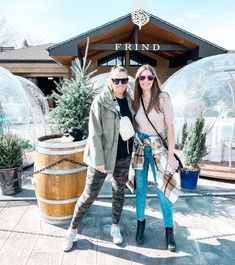 two people standing next to each other in front of a building with large glass domes