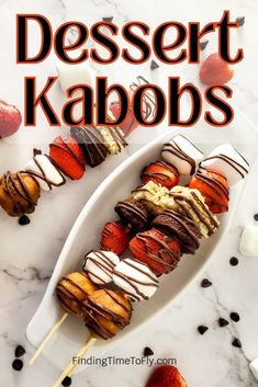 dessert kabobs on a white plate with strawberries