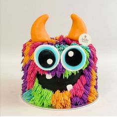 a cake decorated with multicolored icing and fake horns