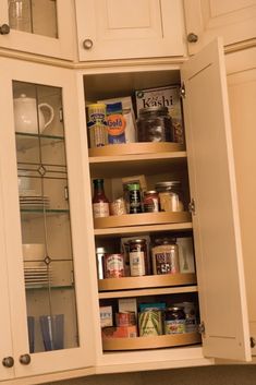 an open cabinet in a kitchen filled with food