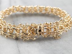 This gold bracelet is beautifully intricate! Interlocking round links form a strong and fluid chain, accented by beads for a lovely profile. A safety chain and locking clasp keep this bracelet secure on your wrist. Metal: 14K Yellow Gold Width: 15 mm Length: 7 Inches Marks: "14K" Stamped on the clasp Luxury Gold-plated Chain Bracelet, Luxury Gold-tone Box Chain Bracelet, Lovely Profile, Luxury Gold-plated Box Chain Bracelet, Luxury Gold-tone Curb Chain Bracelet, Luxury Gold-tone Chain Bracelet With Polished Finish, Bracelet Layering, Gold Link Bracelet, Woven Chain