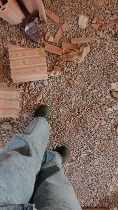 a person standing on top of a wooden floor next to blocks of wood and bricks