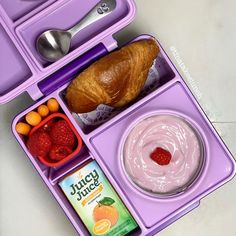 a purple lunch box with fruit, yogurt and croissant