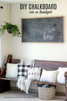 a wooden bench sitting in front of a chalkboard on the wall next to a potted plant