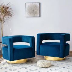 two blue chairs sitting next to each other on a rug in front of a white wall