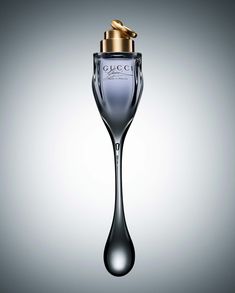 a bottle of perfume with a gold cap on it's top and water droplet in the bottom